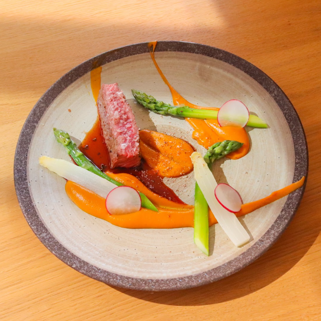 Steak z hovězí roštěné se zeleným lyofilizovaným Kampotským pepřem, mrkvovým pyré, blanšírovaným chřestem a demi-glace omáčkou